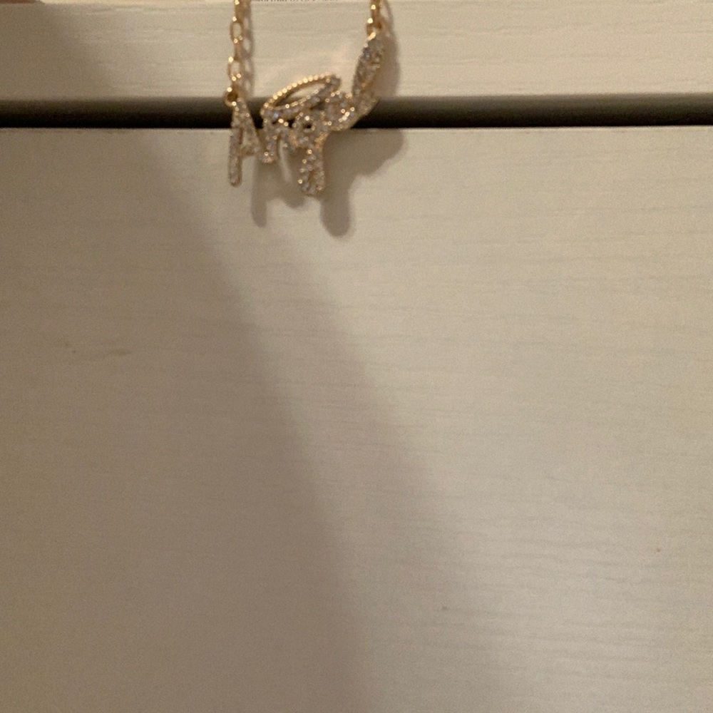 Necklace, gold and has gems on it. In great condition